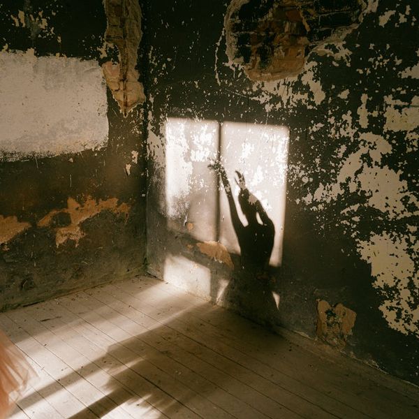 Person feeling energized and stretching towards the sun in a bright room.
